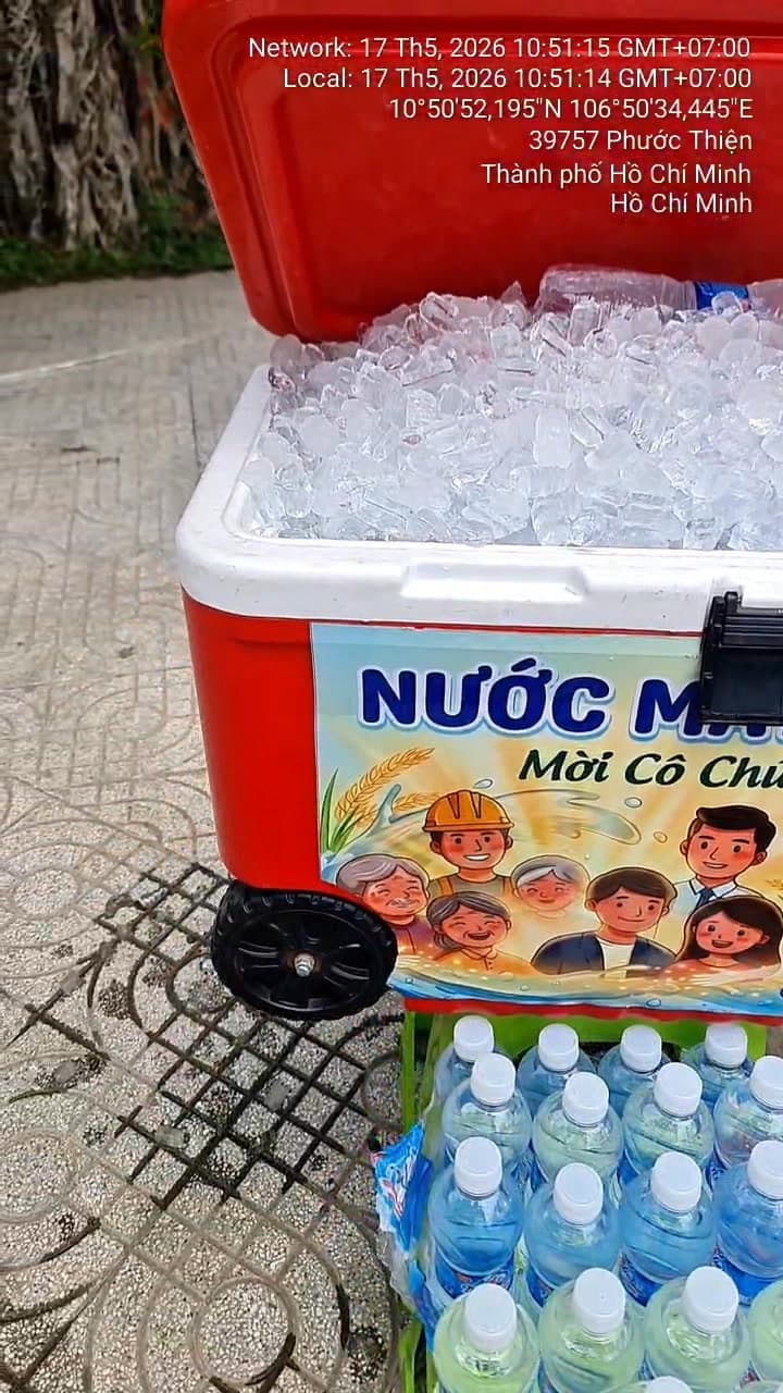 Thùng nước lạnh miễn phí cho người đi đường tại 627 Nguyễn Xiển, hỗ trợ cộng đồng giữa trời nắng nóng. Ai khát đều có thể lấy, không cần mua. - 1/3